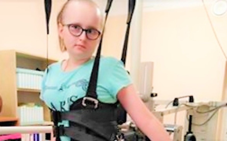 Dziewczynka w specjalnym urządzeniu rehabilitacyjnym.