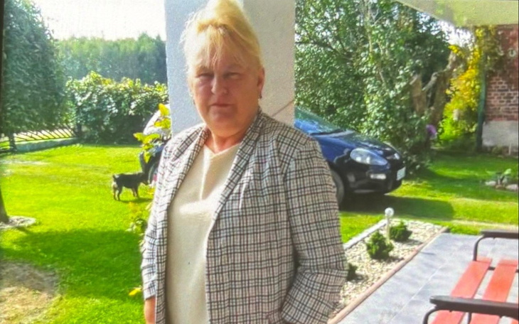 Kobieta w eleganckim ubraniu stoi na zewnątrz.