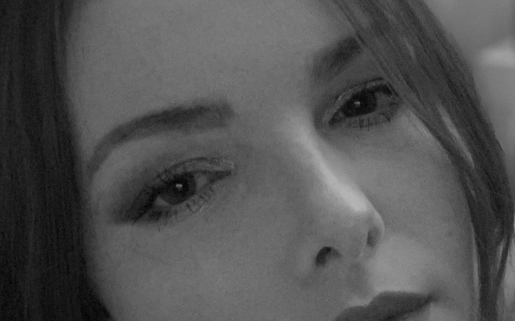 Portret kobiety w czerni, z wyrazistym spojrzeniem.