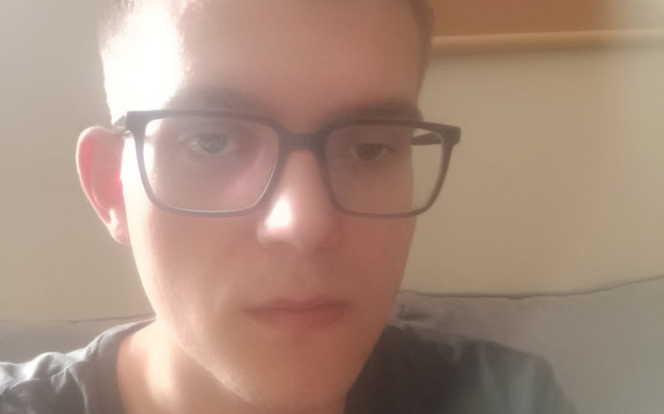 Młody mężczyzna w okularach, patrzący w stronę kamery.