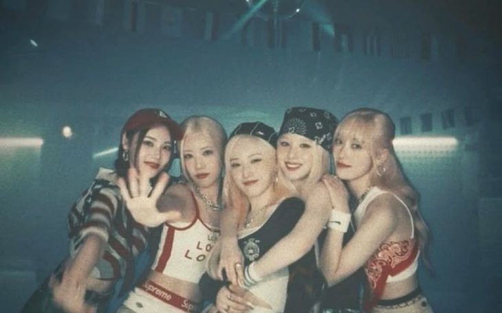 Grupa pięciu dziewczyn w modnych strojach, pozujących razem.