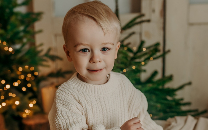 Mężczyzna w szarej czapce, uśmiechający się nad wodą.