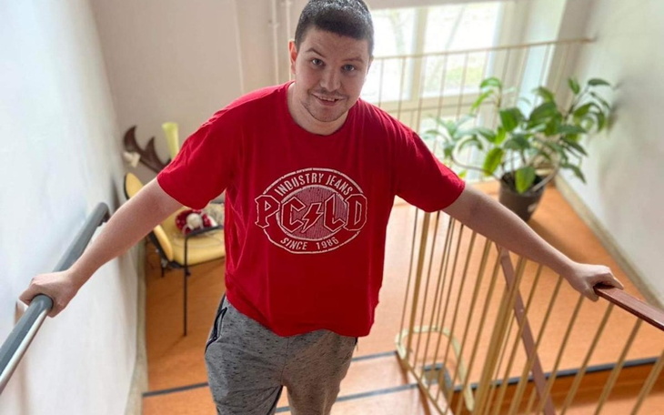 Mężczyzna w czerwonej koszulce na schodach.