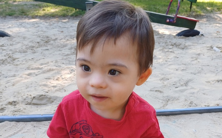 Mały chłopiec na placu zabaw, z ciekawym wyrazem twarzy.