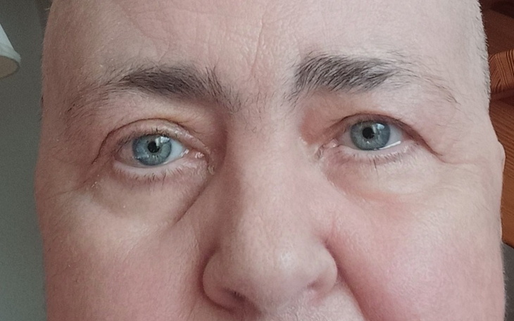 Zbliżenie na twarz mężczyzny z niebieskimi oczami.