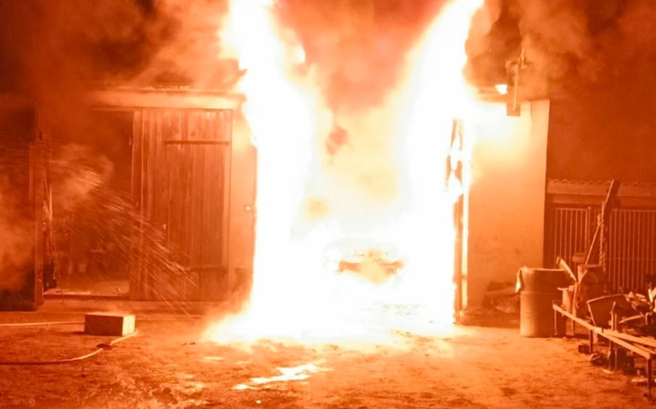 Pożar w budynku, ogień wydobywający się z drzwi.