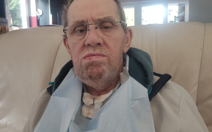 Mężczyzna w fotelu, z wyrazem twarzy pełnym smutku.