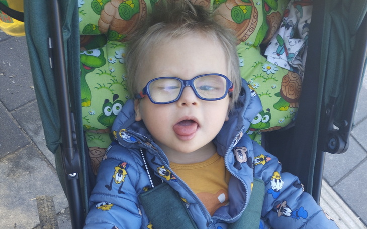 Małe dziecko w wózku, robiące zabawne miny.