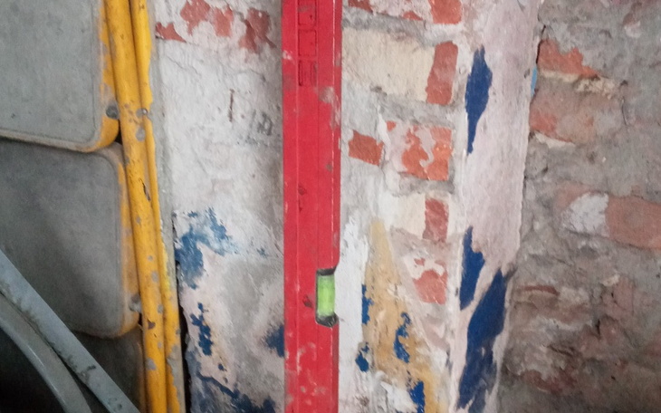 Poziomica oparta o ścianę w starym budynku.