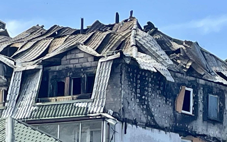 Zniszczony budynek po pożarze, z uszkodzonym dachem.