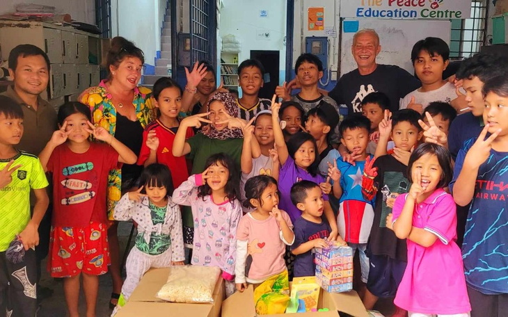 Grupa dzieci i dorosłych w centrum edukacyjnym, wszyscy pozują do zdjęcia.