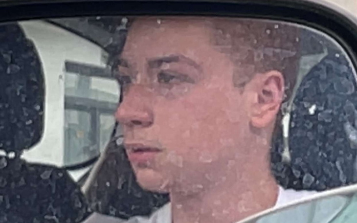 Młody chłopak patrzący przez brudną szybę samochodu.