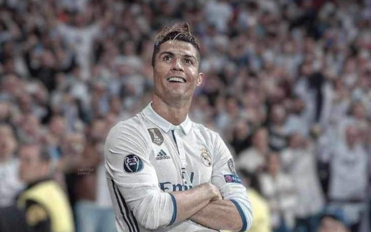 Cristiano Ronaldo w białym stroju, uśmiechnięty na boisku.