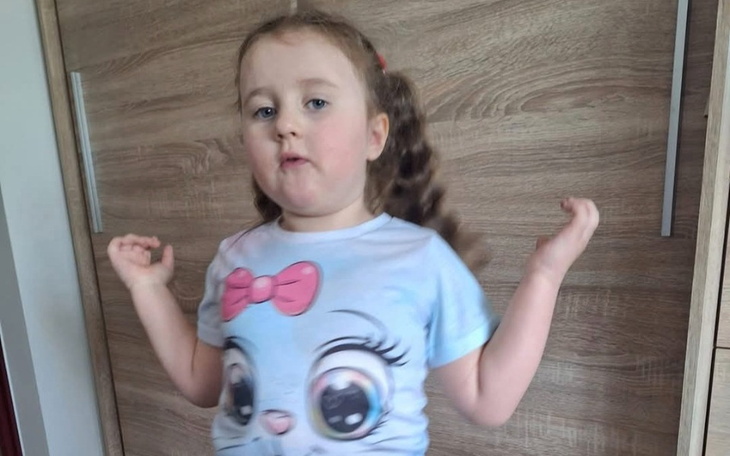 Mała dziewczynka w koszulce z postacią z kreskówki.