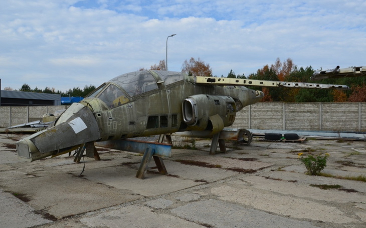 Zardzewiały samolot wojskowy, stojący na opuszczonym placu.