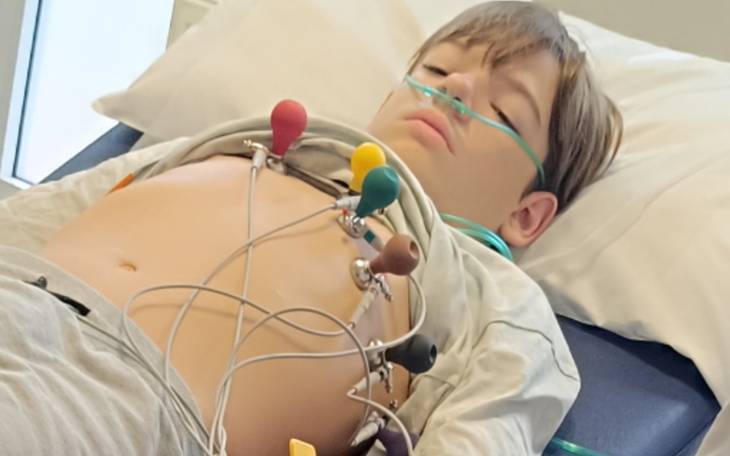 Chłopiec leżący w szpitalu z podłączonymi monitorami.