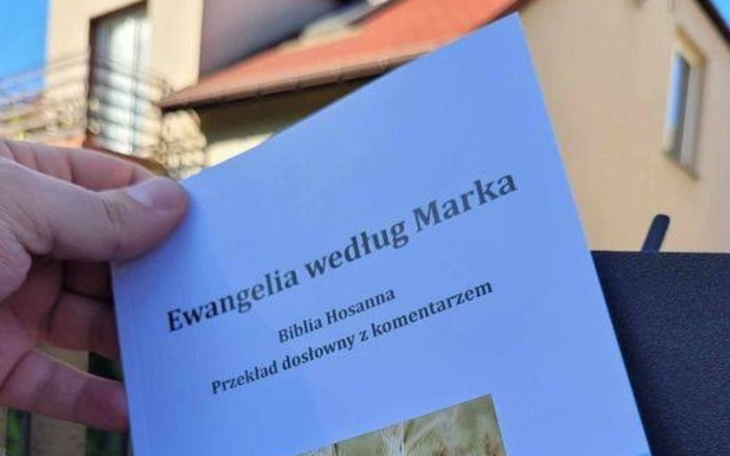 Osoba trzymająca książkę z Ewangelią według Marka.