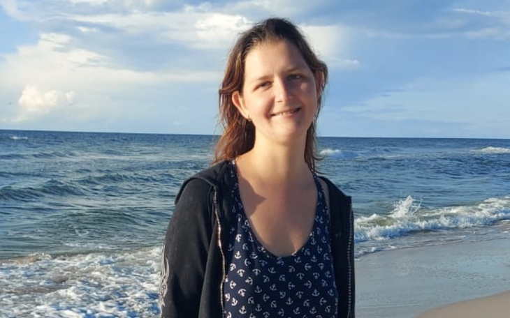 Kobieta na plaży, ciesząca się słońcem i morzem.