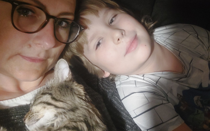 Kobieta z dzieckiem i kotem, spędzają czas razem.