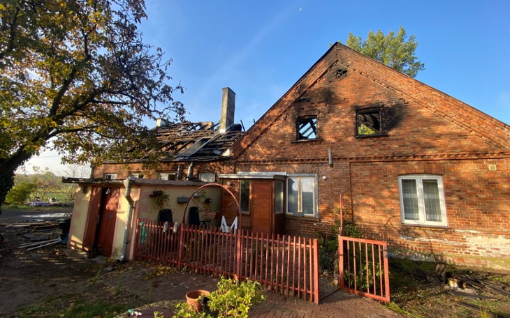 Zniszczony dom z uszkodzoną dachówką.