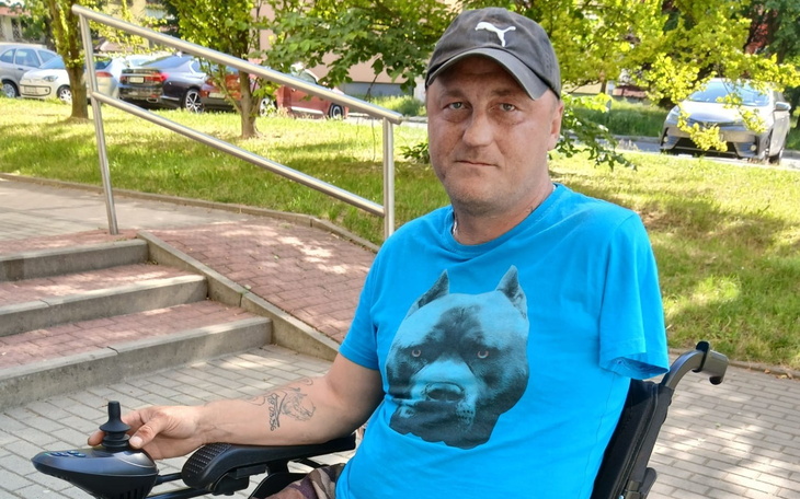 Mężczyzna na wózku inwalidzkim w parku.