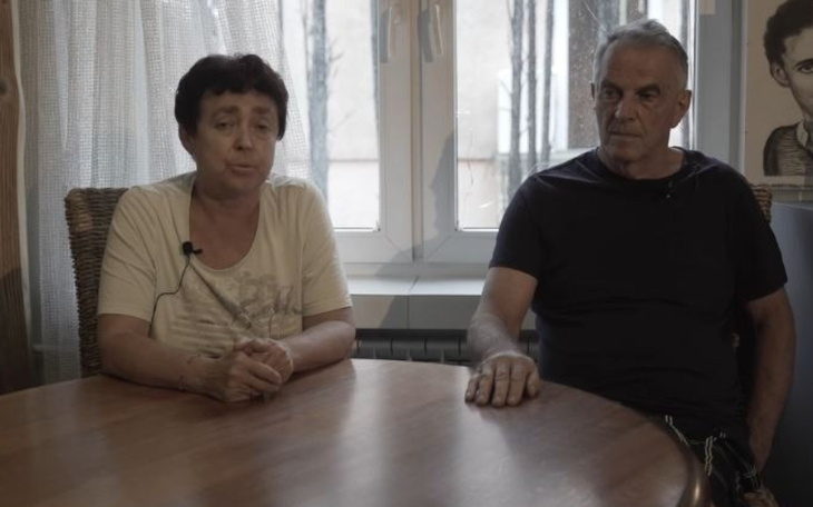 Dwoje ludzi siedzących przy stole, rozmawiających.