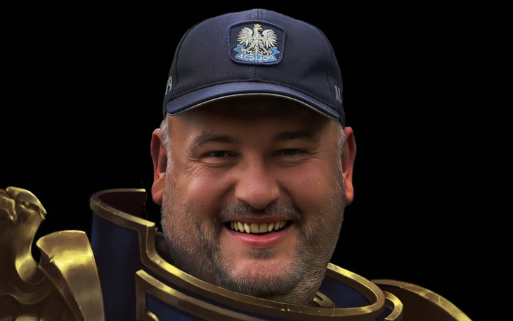 Mężczyzna w mundurze, uśmiechający się do kamery.