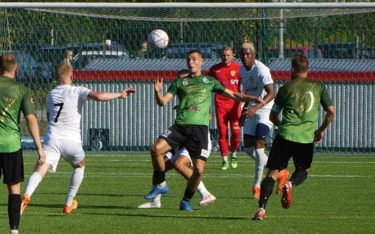 Zawodnicy w akcji podczas meczu piłkarskiego na boisku.