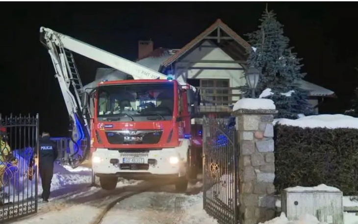 Wóz strażacki przy domu, akcja ratunkowa w nocy.