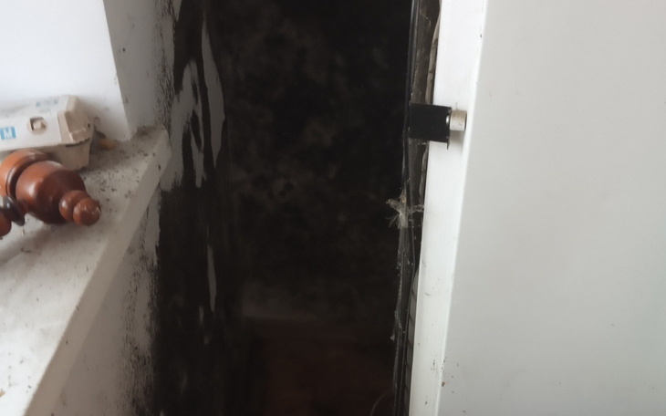 Ciemny korytarz z pleśnią, z zamkniętymi drzwiami.