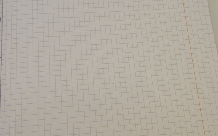 Pusty zeszyt w kratkę, gotowy do zapisania.