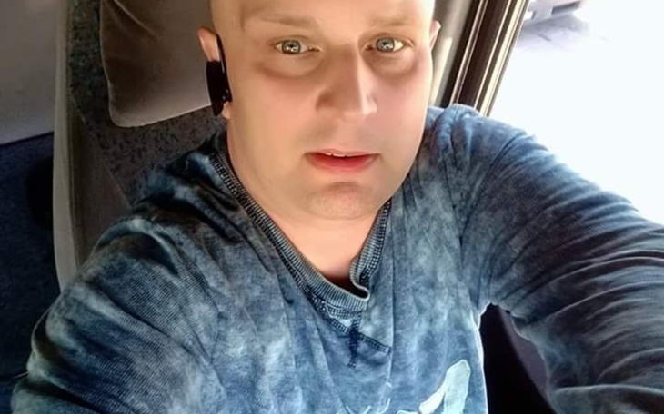 Mężczyzna robi selfie w samochodzie, wygląda na zaskoczonego.