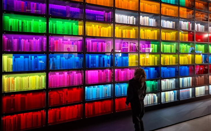 Kolorowa ściana z książkami w różnych odcieniach.