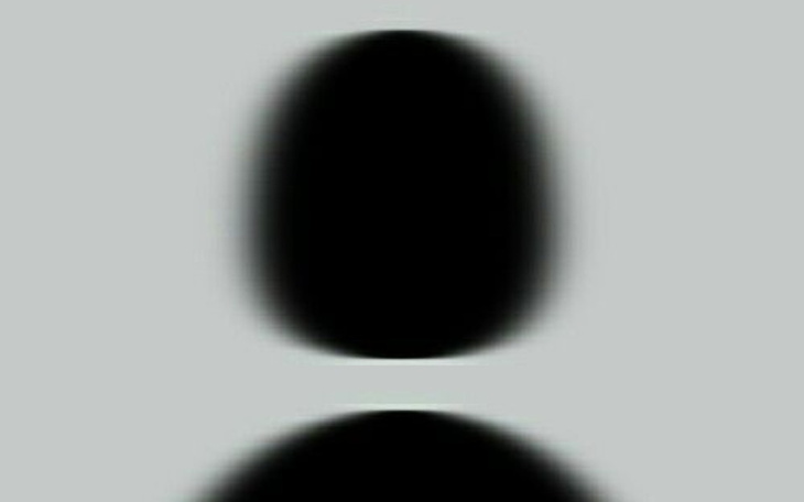 Abstrakcyjny obraz z ciemnymi kształtami na szarym tle.