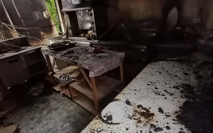 Zniszczona kuchnia po pożarze, z bałaganem na stole.