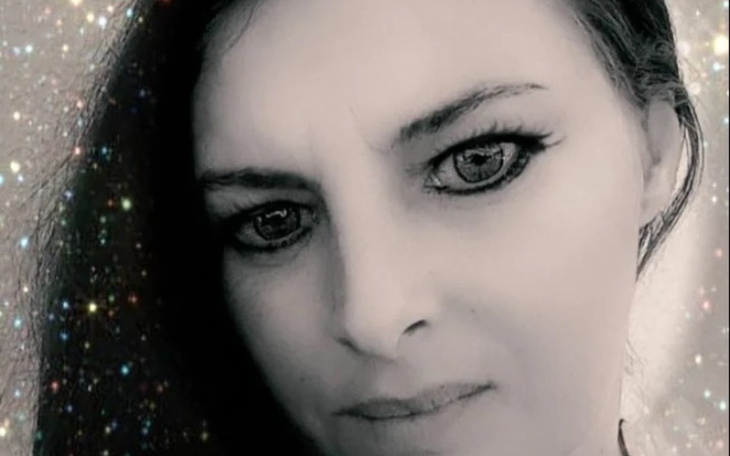 Portret kobiety z wyrazistym makijażem i efektownym tłem.