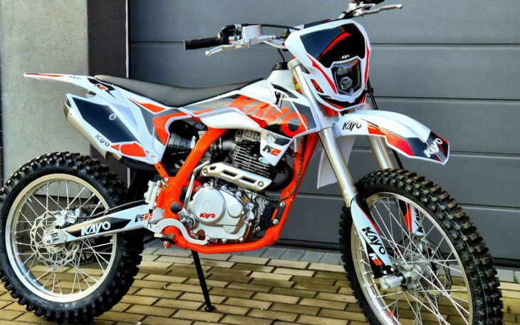 Motocykl terenowy w kolorach białym i pomarańczowym.