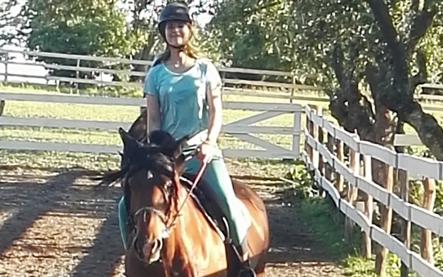 
        Kobieta jeżdżąca na koniu na tle zielonego krajobrazu.
    