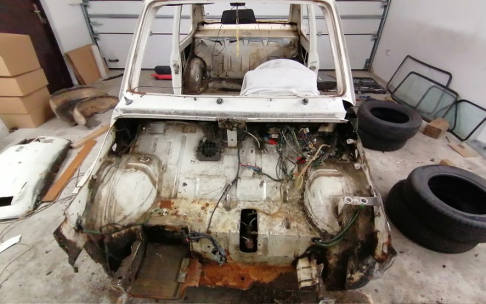 
        Widok na wnętrze starego samochodu w trakcie renowacji.
    