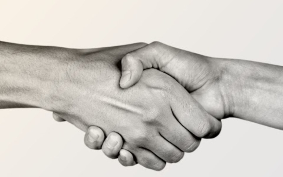 
        Dwie ręce w uścisku, symbolizujące współpracę i zaufanie.
    