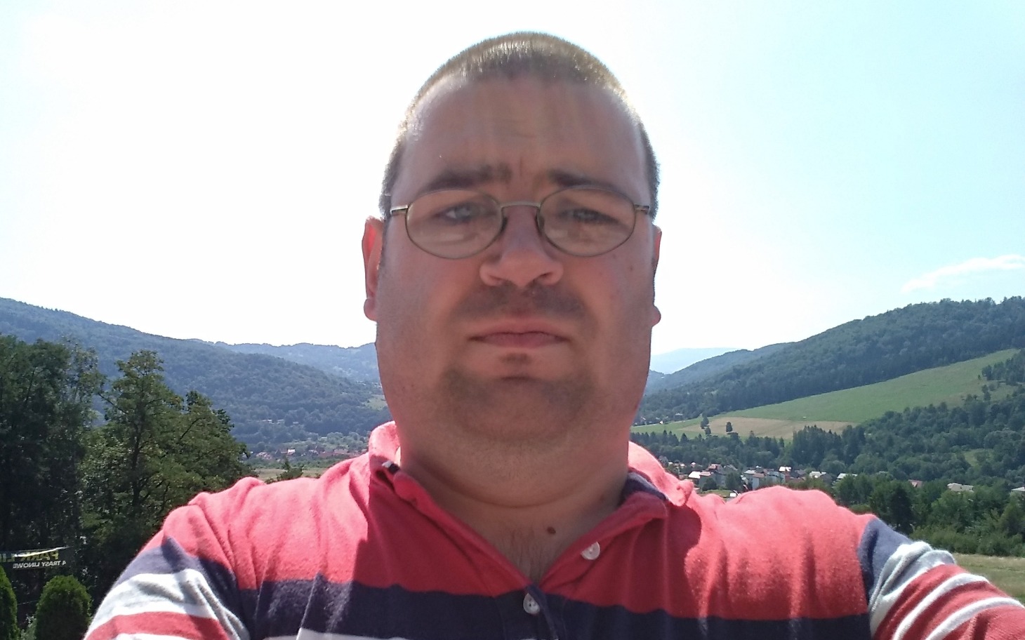 
        Mężczyzna na tle górskiego krajobrazu.
    