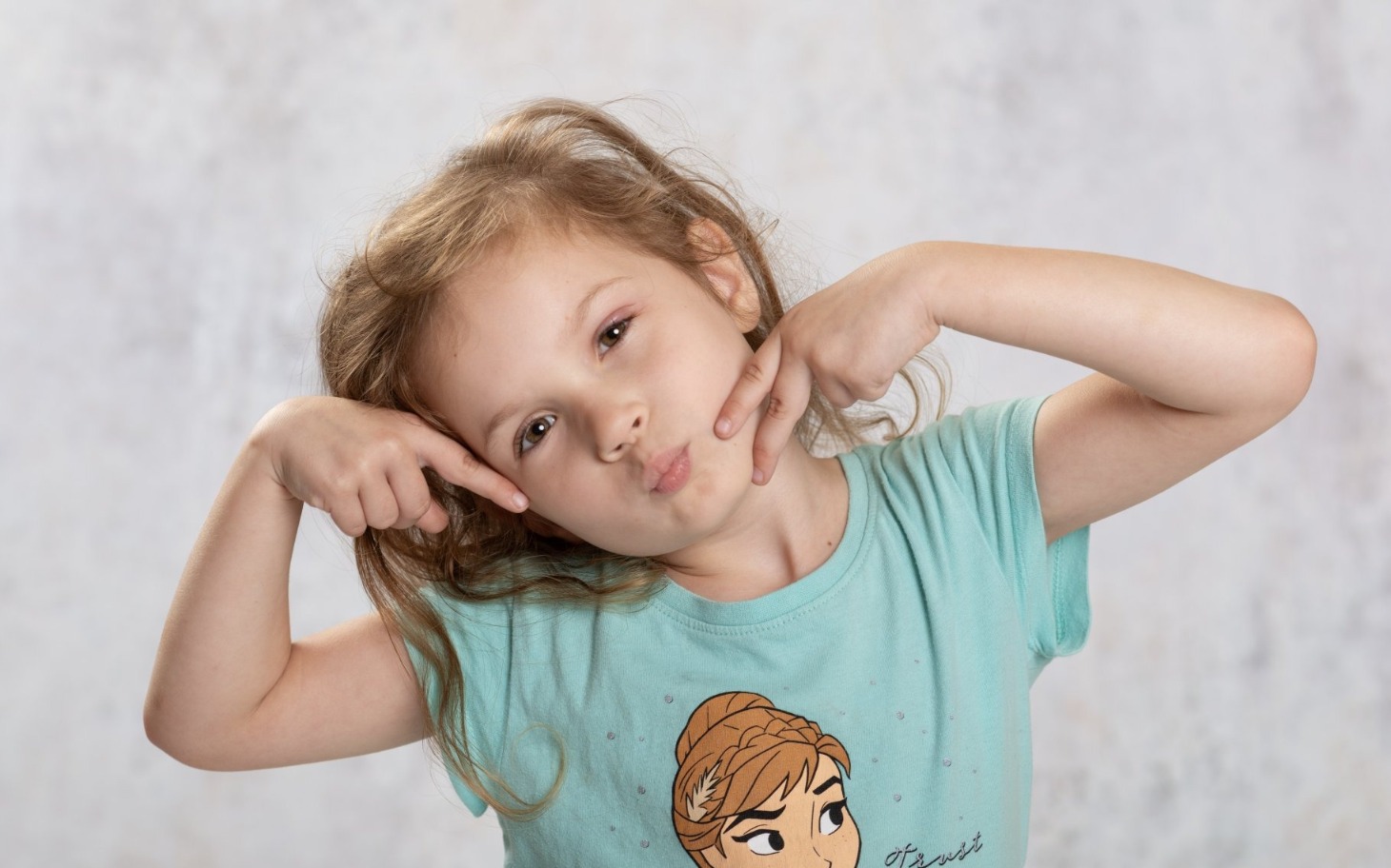 
        Dziewczynka w niebieskiej koszulce robiąca zabawne miny.
    