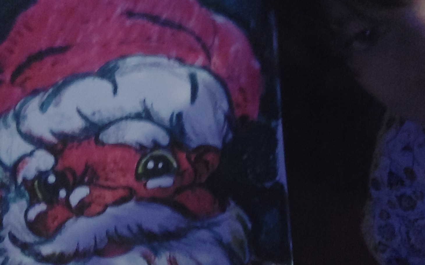 
        Zbliżenie na rysunek Świętego Mikołaja z wyrazistymi oczami.
    