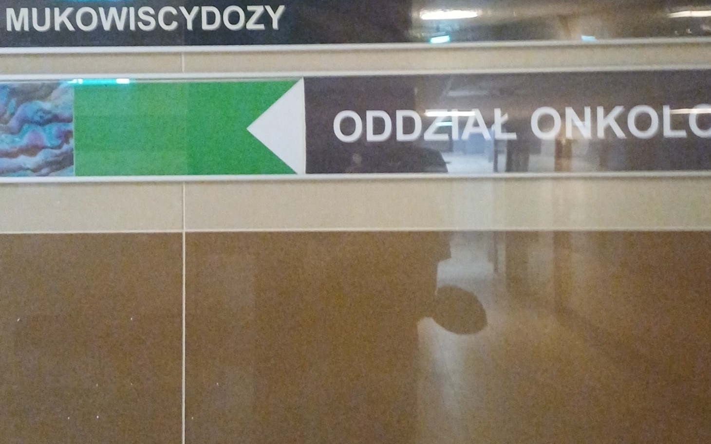 
        Tablica informacyjna z kierunkiem do oddziału onkologii.
    