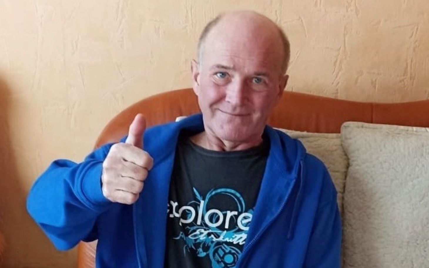 
        Mężczyzna w niebieskiej bluzie z uśmiechem i kciukiem w górę.
    