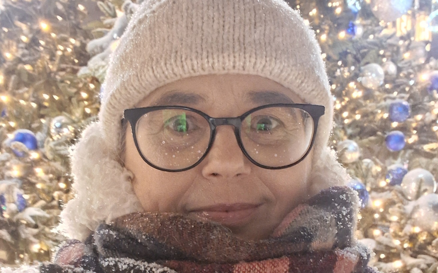 Osoba w zimowej scenerii z ośnieżonymi drzewami.