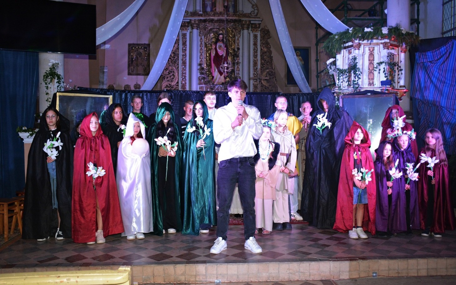 Grupa ludzi w strojach, występujących na scenie.