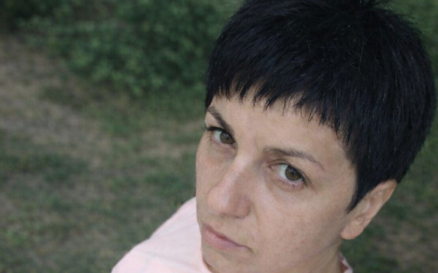 
        Kobieta z krótkimi włosami, patrząca w obiektyw.
    