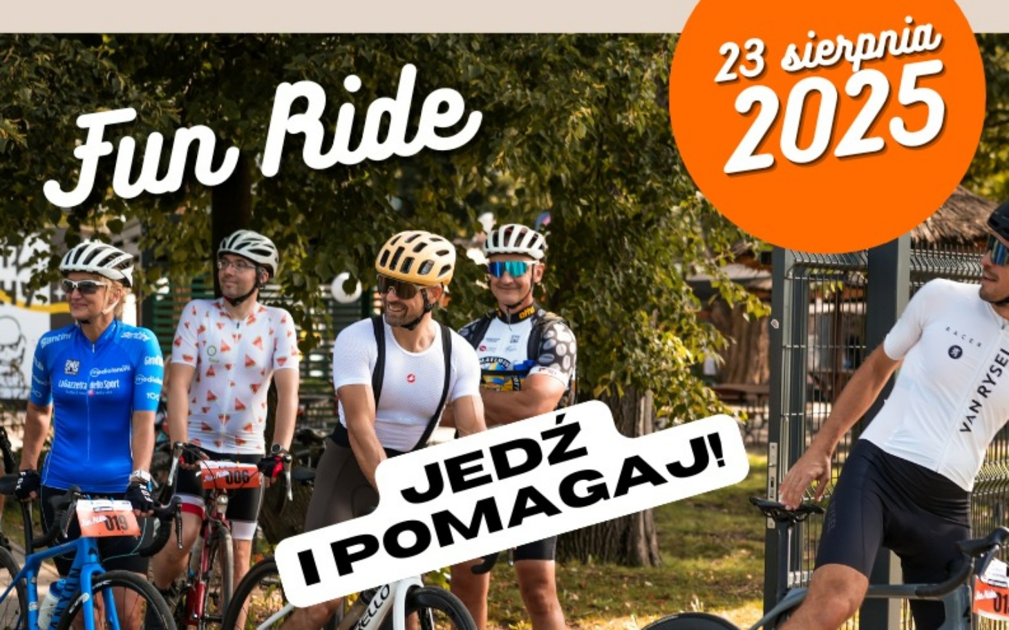 
        Grupa rowerzystów na wydarzeniu charytatywnym, uśmiechniętych.
    