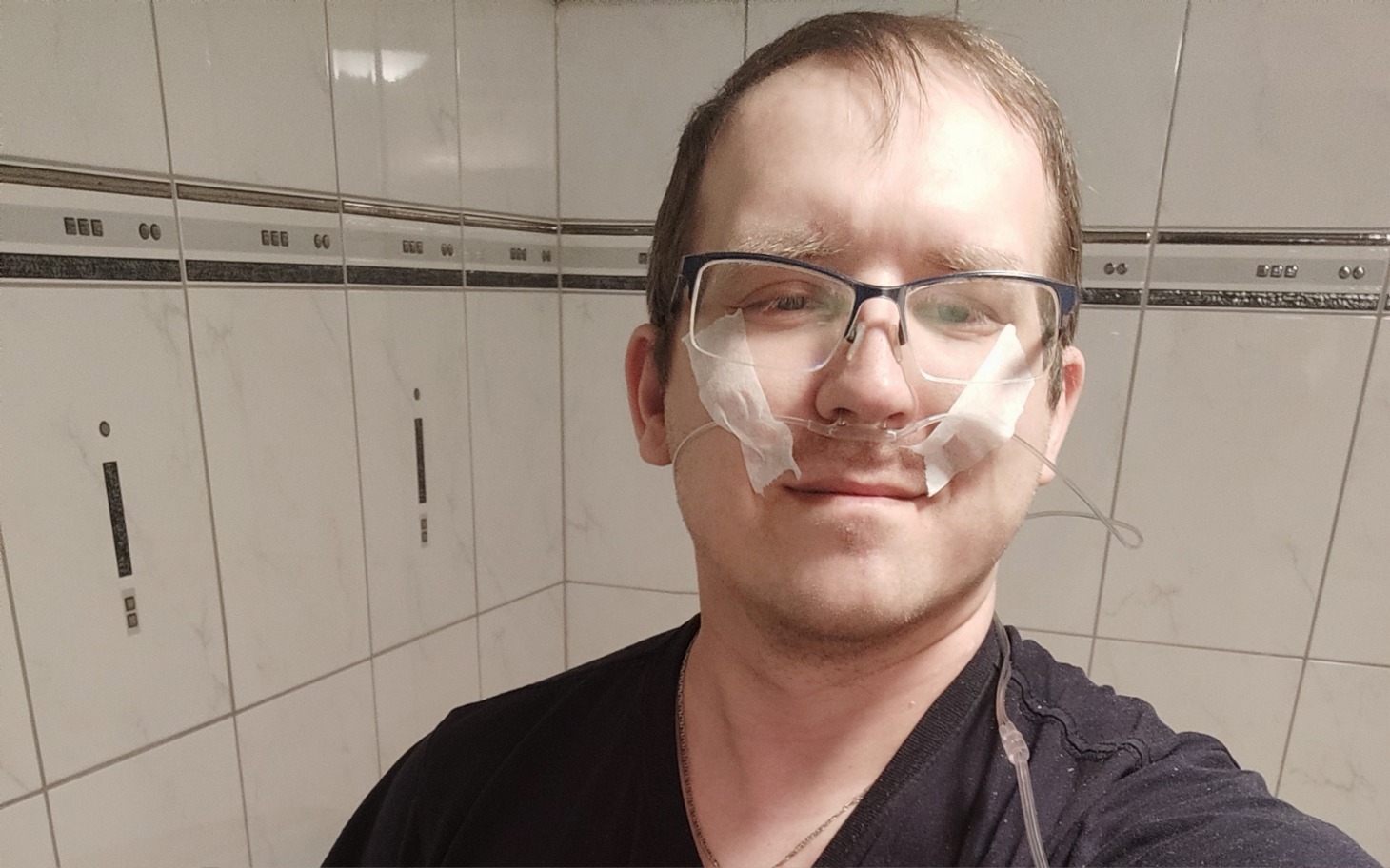 
        Mężczyzna z okularami, uśmiechający się w lustrze.
    